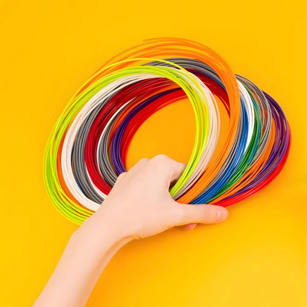 Main tenant plusieurs recharges de filaments 3D aux couleurs vives.